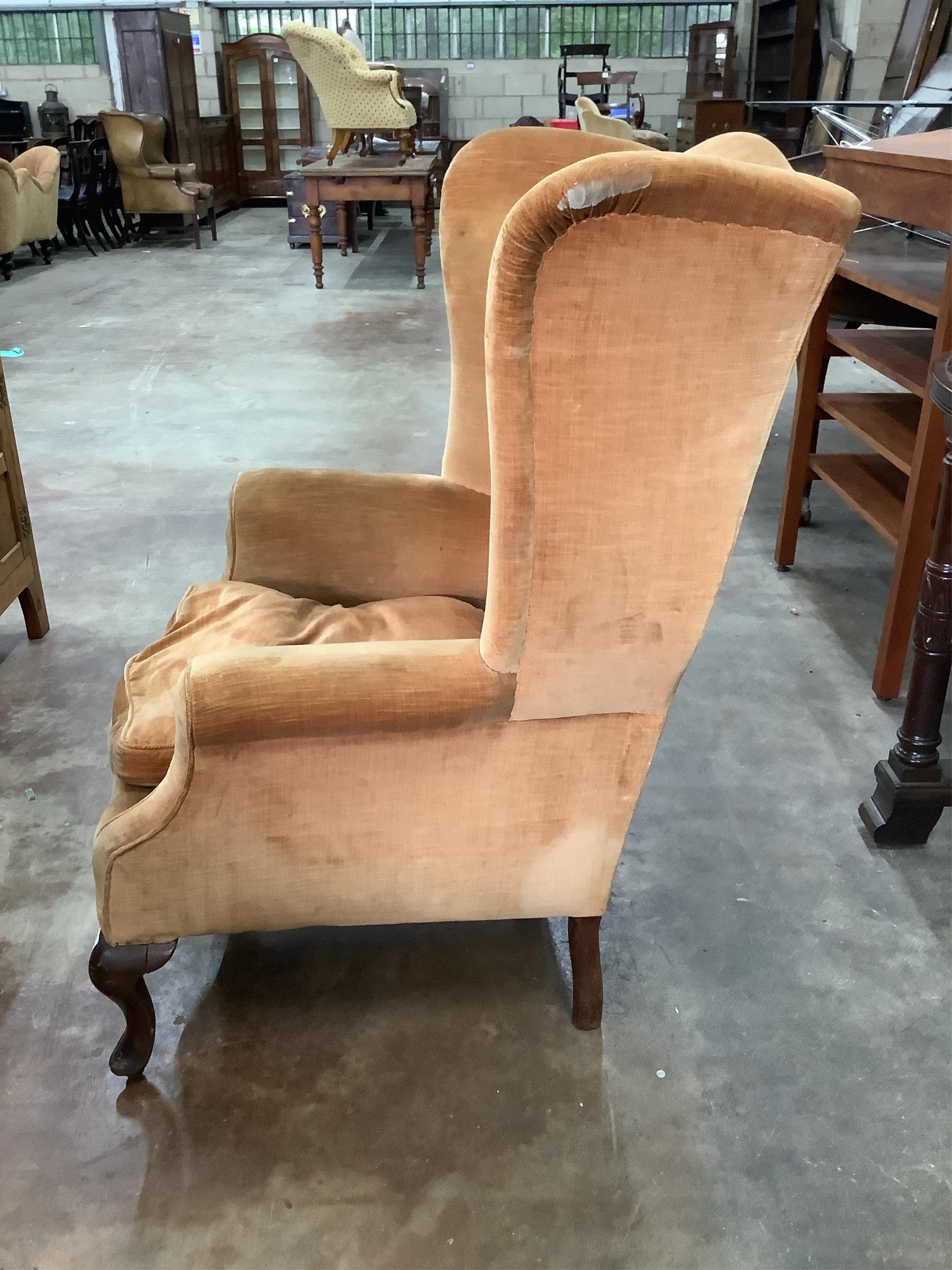 An early 20th century upholstered wing armchair, width 81cm, depth 72cm, height 110cm. Condition - fair